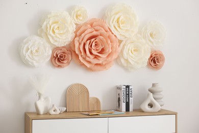 Photo of Beautiful decorative paper flowers on wall in room