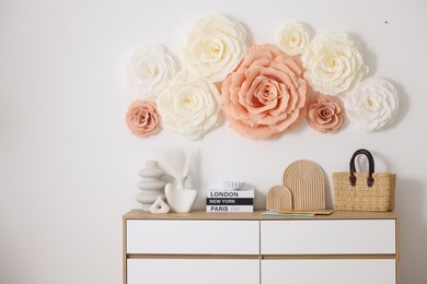 Photo of Beautiful decorative paper flowers on wall in room