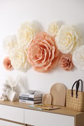 Photo of Beautiful decorative paper flowers on wall in room