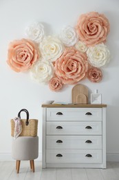 Beautiful decorative paper flowers on wall in room