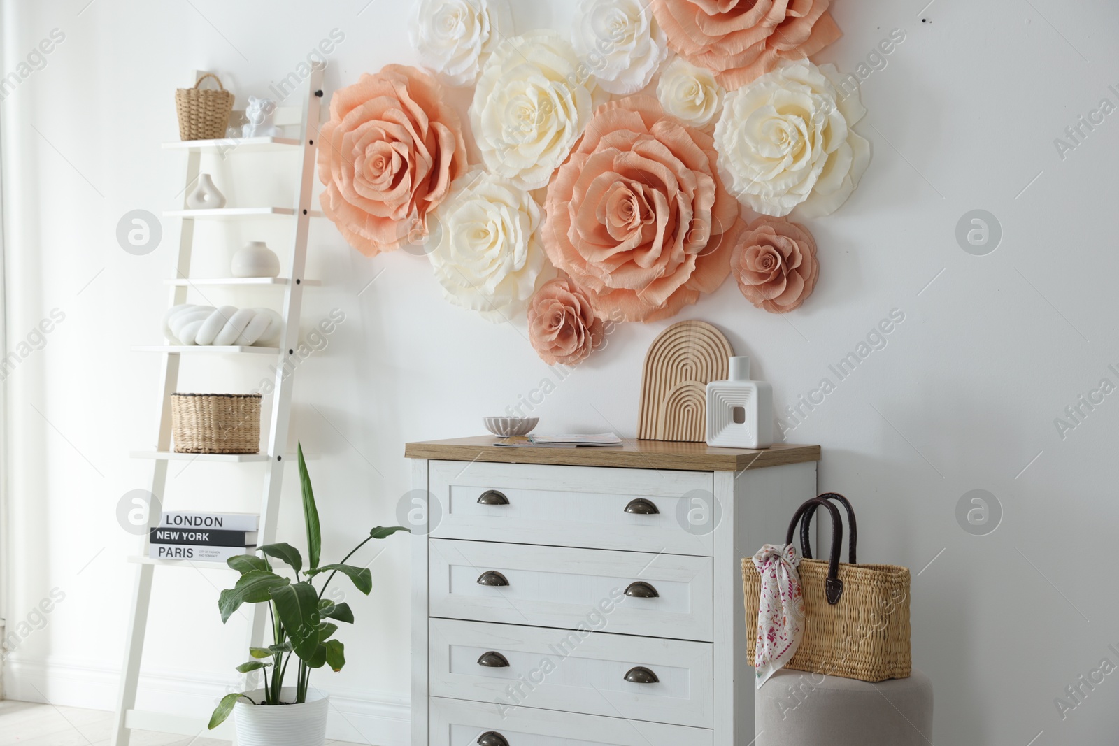 Photo of Beautiful decorative paper flowers on wall in room