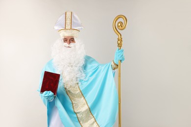 Photo of Saint Nicholas with book and crozier on gray background