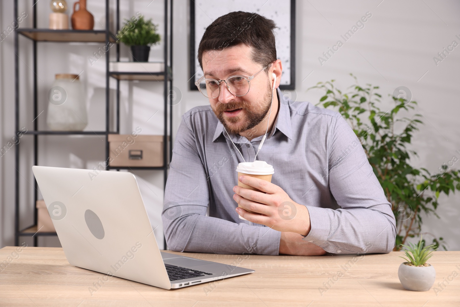 Photo of Online speaker streaming with laptop at table indoors