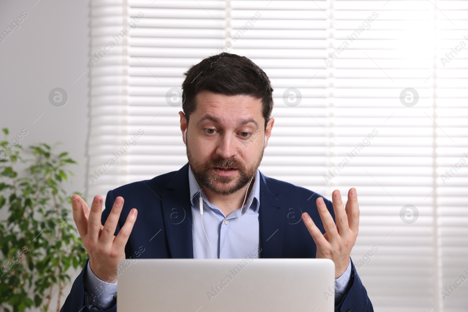 Photo of Online speaker streaming webinar with laptop indoors