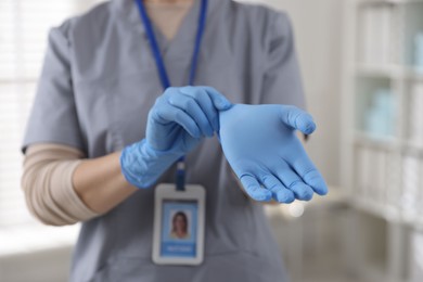 Medical worker putting gloves in hospital, closeup