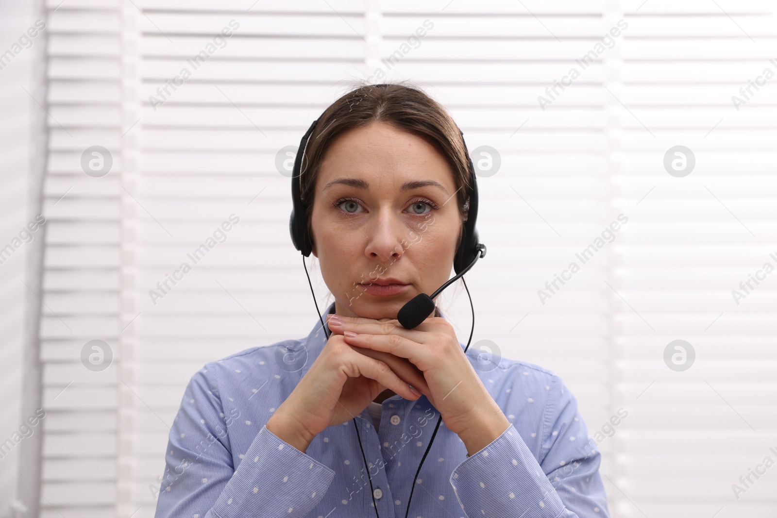 Photo of Online speaker in headset streaming webinar indoors, view from web camera