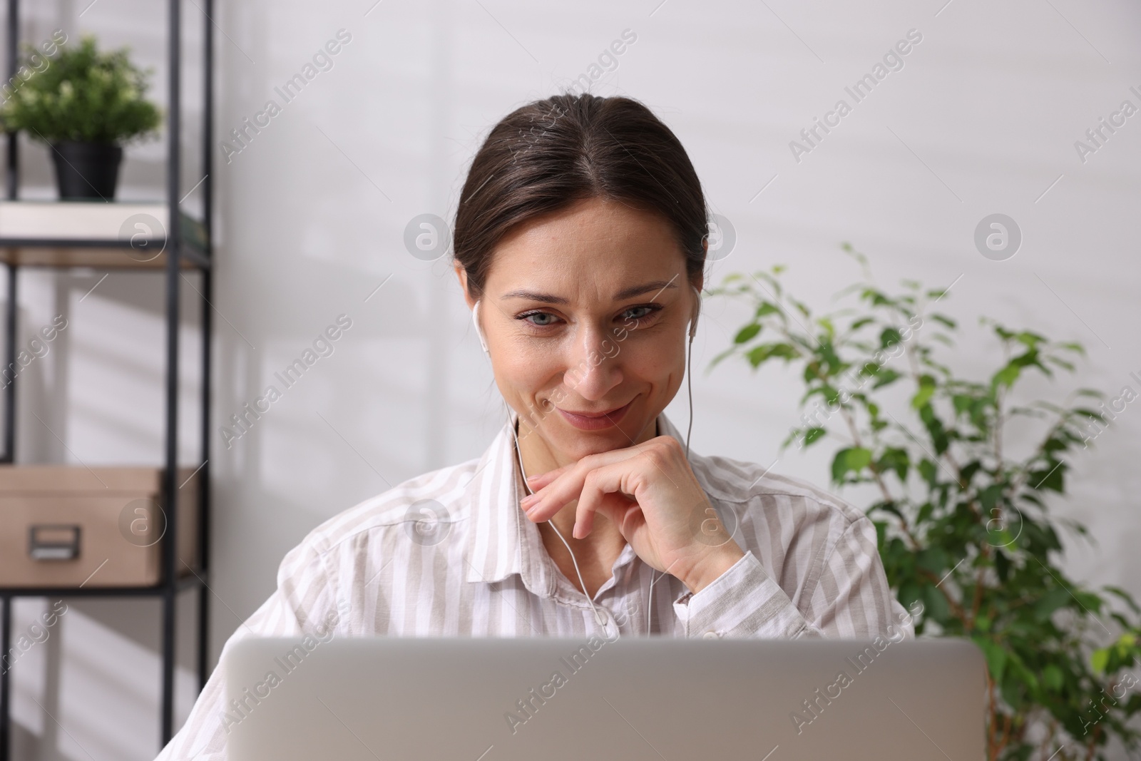 Photo of Online speaker streaming webinar with laptop indoors