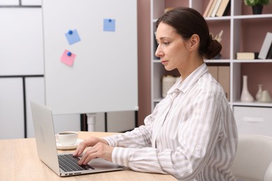 Photo of Online speaker streaming webinar with laptop at table indoors