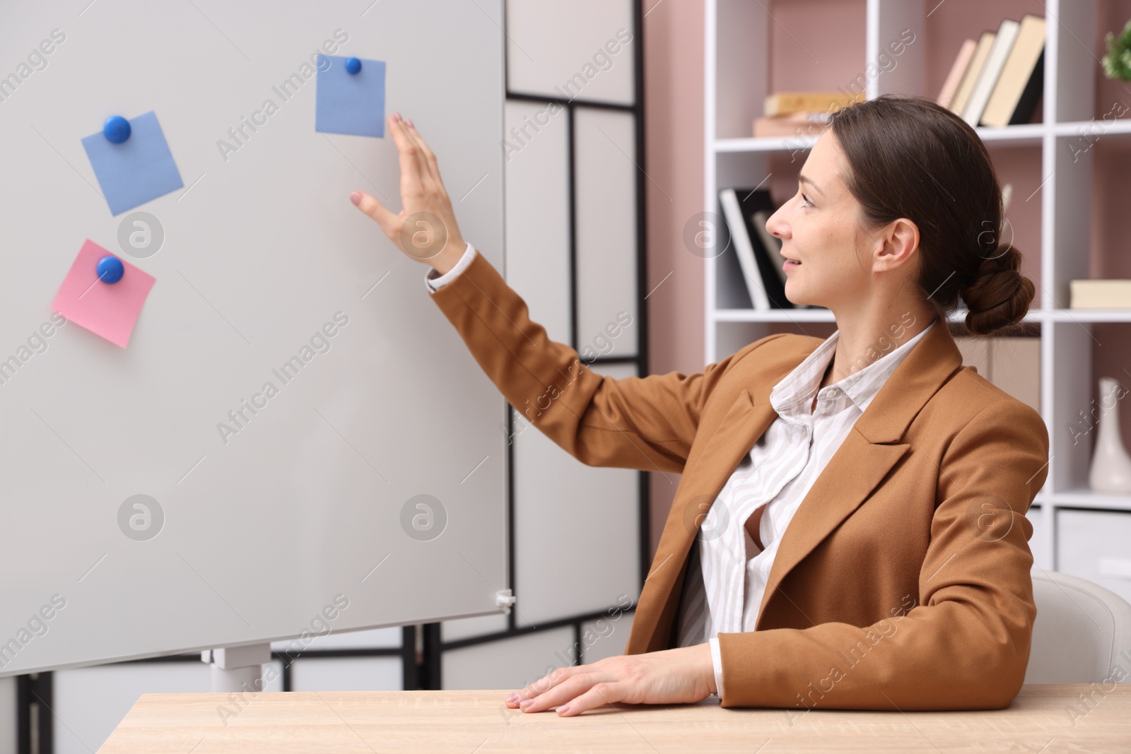 Photo of Online speaker performing webinar near flip chart indoors