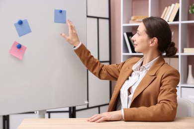 Online speaker performing webinar near flip chart indoors