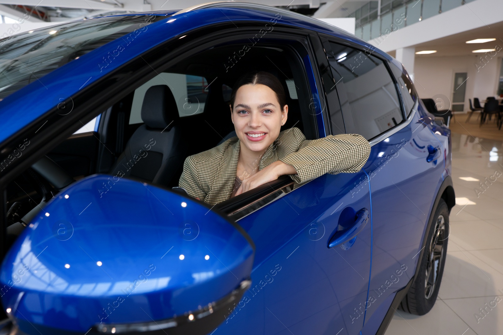 Photo of Happy woman inside new car in salon