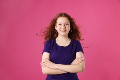 Beautiful teenage girl with freckles on pink background