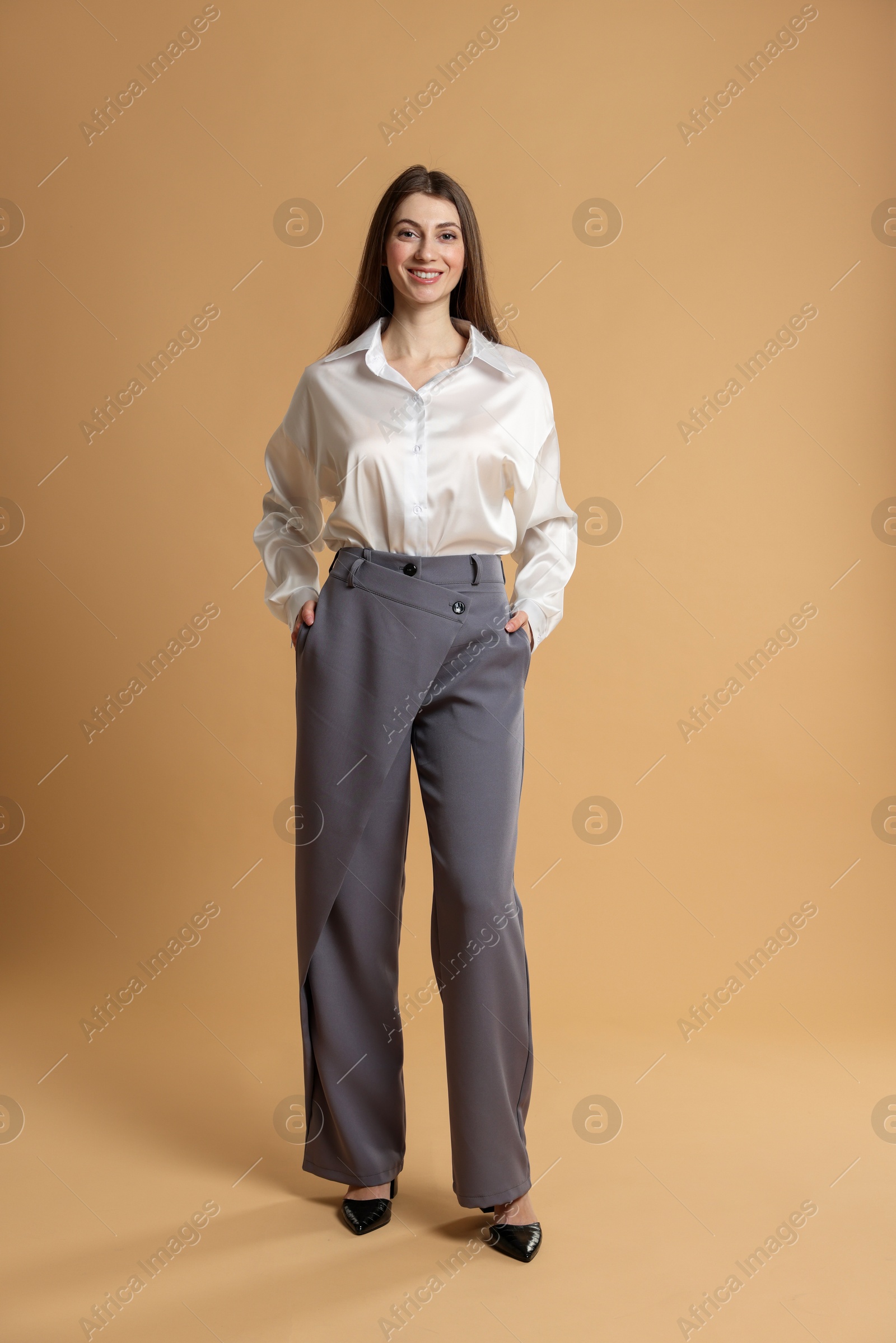 Photo of Beautiful woman in stylish outfit on beige background