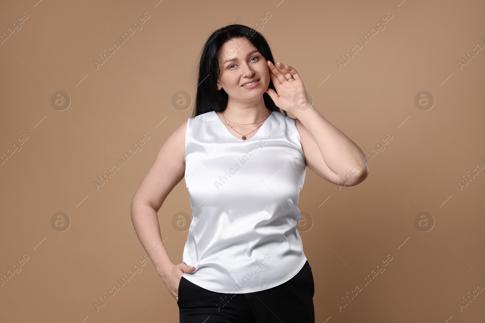 Photo of Portrait of smiling plus size model on beige background. Overweight