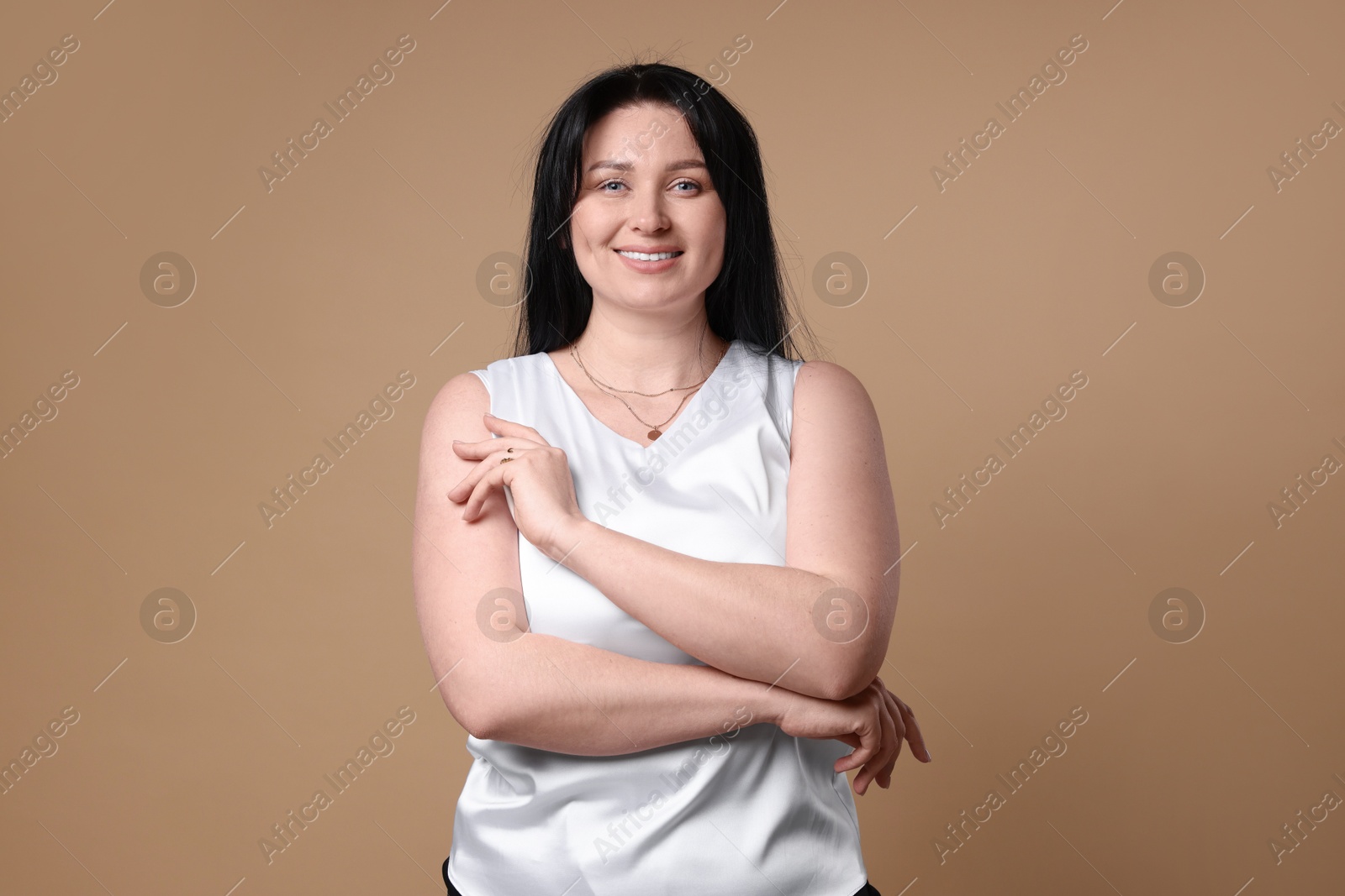 Photo of Portrait of smiling plus size model on beige background. Overweight