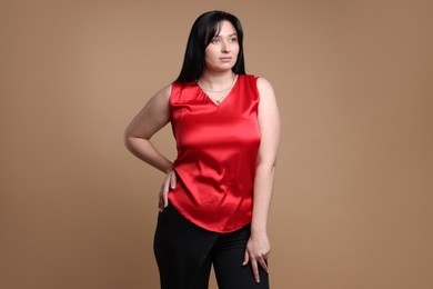 Photo of Portrait of charming plus size model on beige background. Overweight