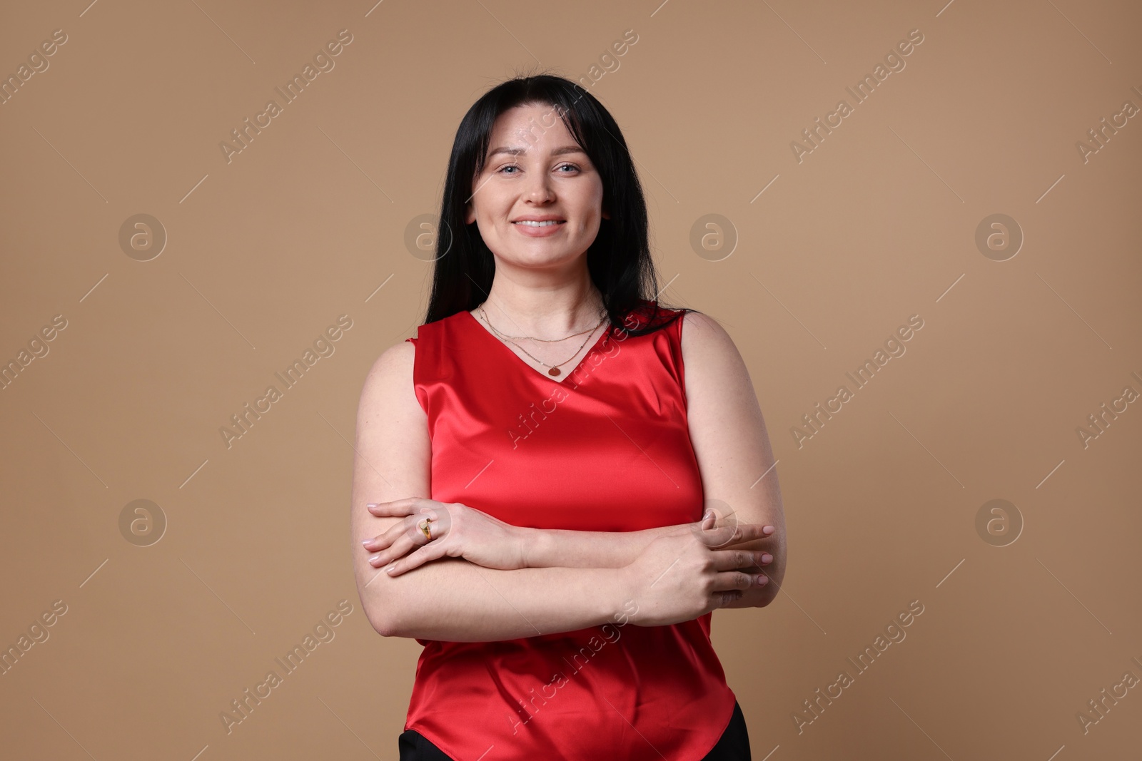 Photo of Portrait of smiling plus size model on beige background. Overweight