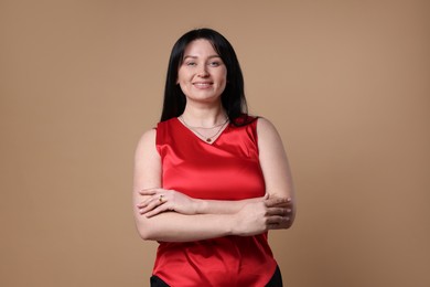 Portrait of smiling plus size model on beige background. Overweight