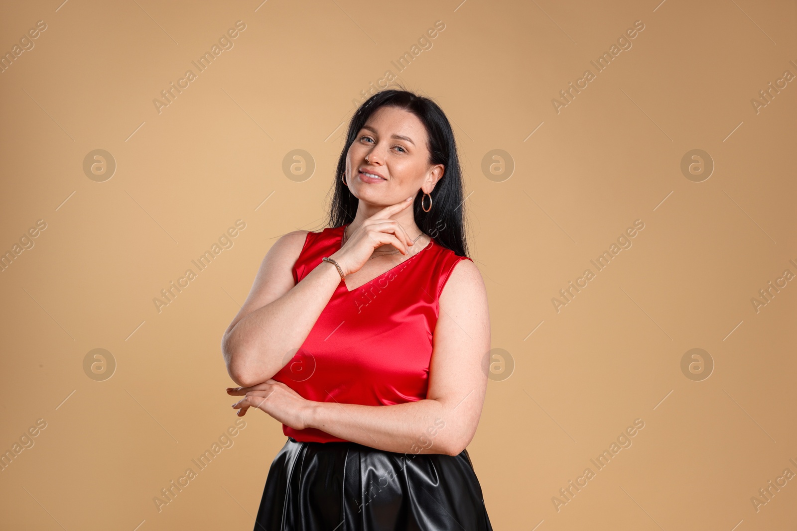 Photo of Portrait of smiling plus size model on beige background. Overweight