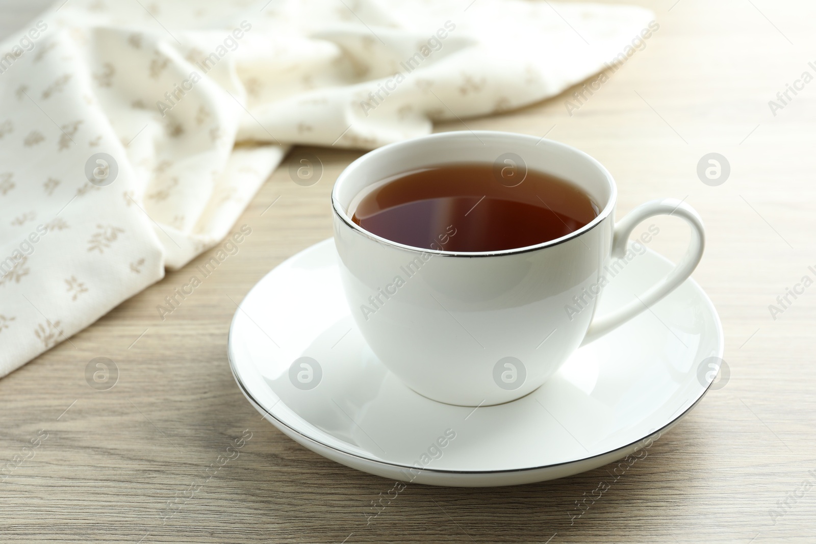 Aromatic tea in cup on wooden table, closeup Photo of Aromatic tea in cup on wooden table, closeup