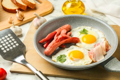 Photo of Tasty brunch. Fried eggs, sausages, bacon and spatula on white marble table, closeup