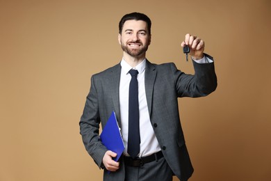 Photo of Cheerful salesman with car key and clipboard on beige background