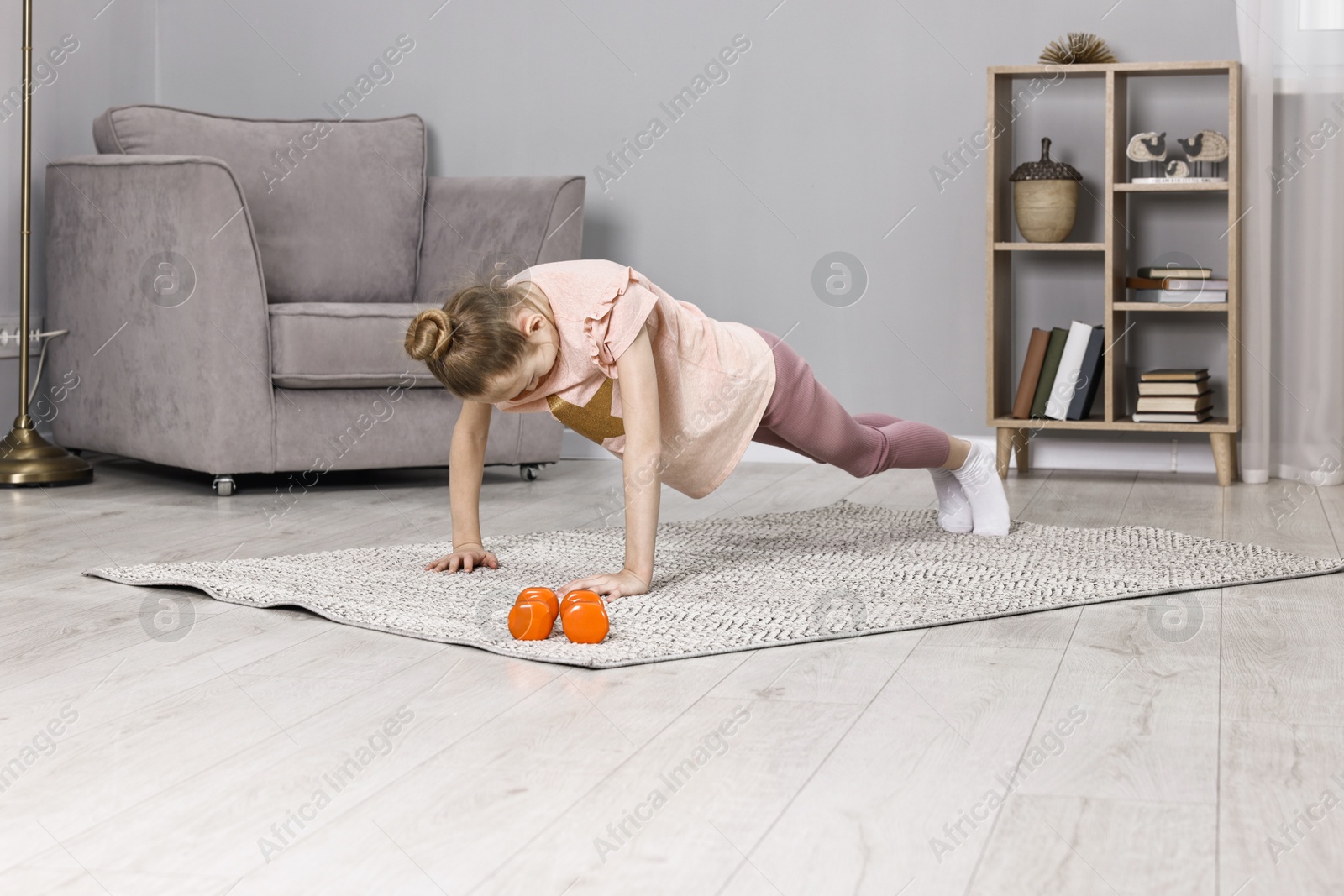 Photo of Little girl exercising at home. Morning routine