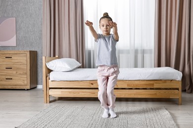 Photo of Little girl exercising at home. Morning routine