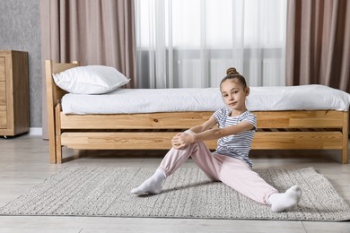 Photo of Little girl exercising at home. Morning routine