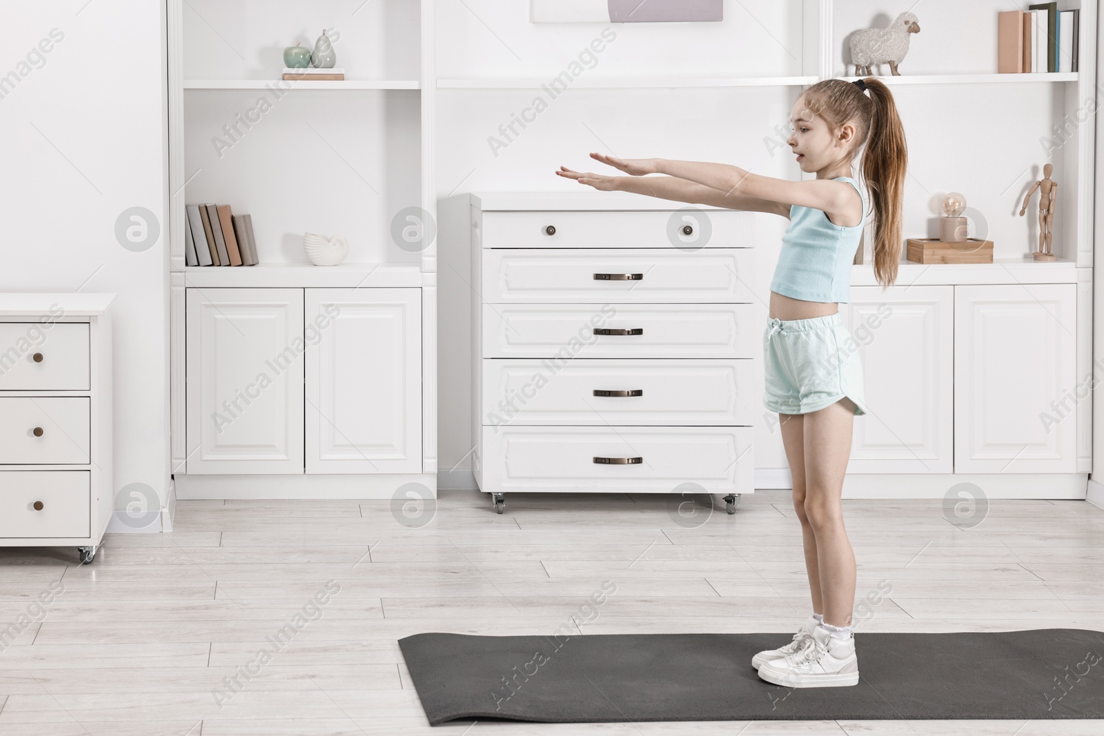 Photo of Little girl exercising at home, space for text. Morning routine