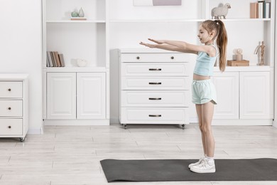 Little girl exercising at home, space for text. Morning routine