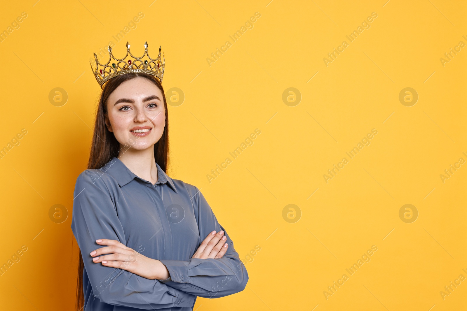 Photo of Happy woman in elegant crown on yellow background. Space for text