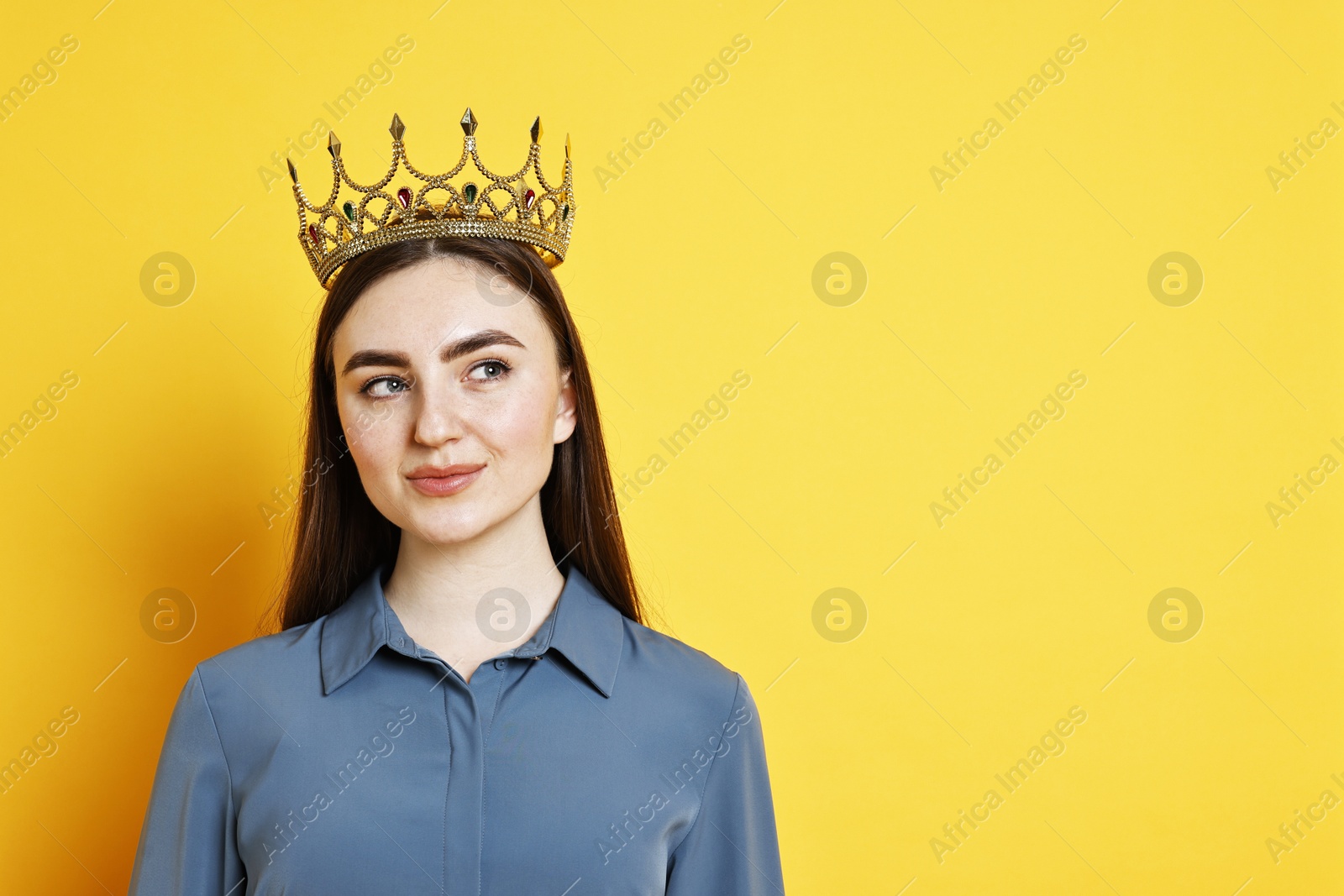 Photo of Woman in elegant crown on yellow background. Space for text