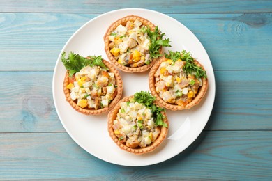 Photo of Tartlets with delicious filling on blue wooden table, top view