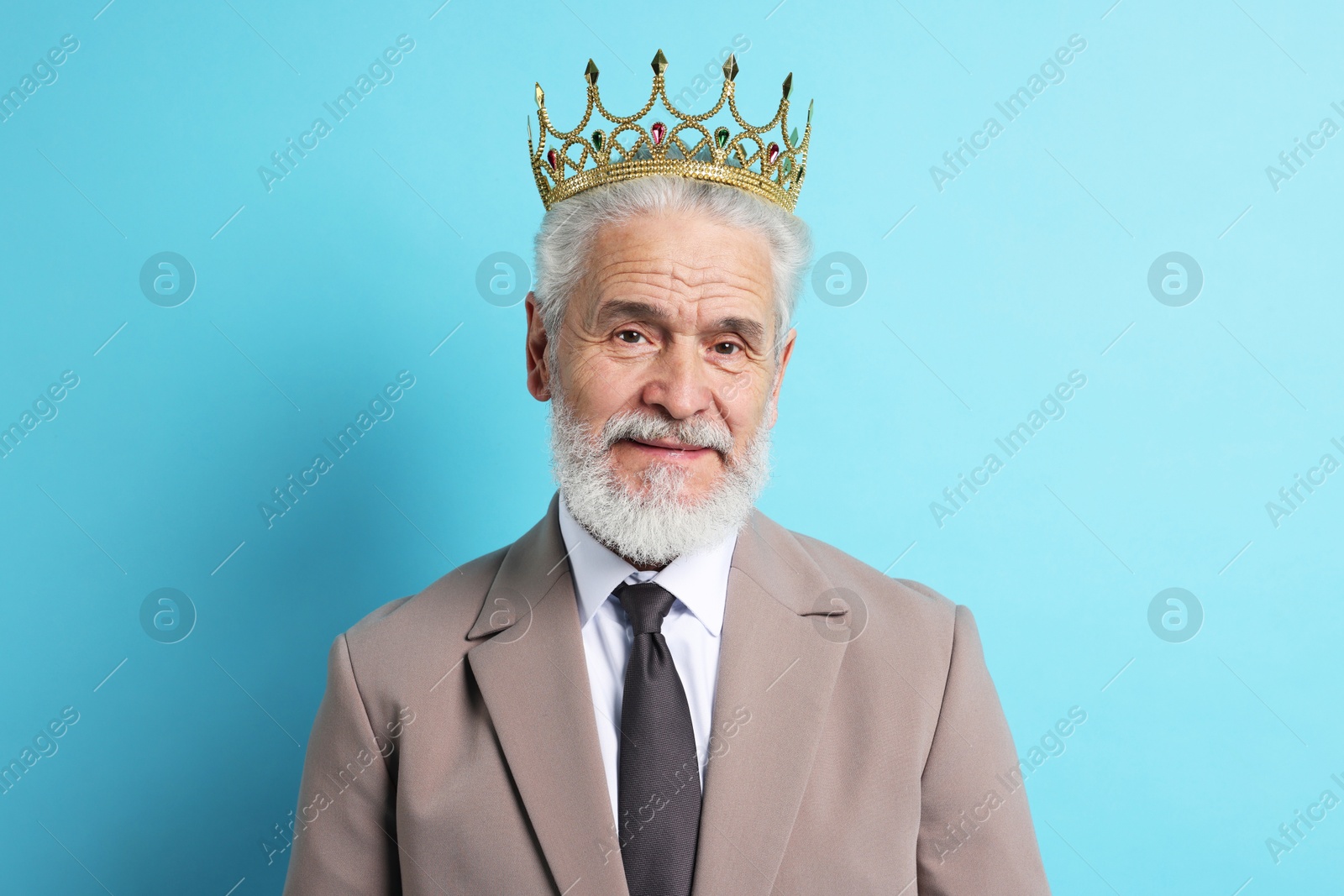 Photo of Senior man wearing luxury crown on light blue background