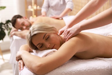 Couple receiving relaxing massage in spa salon, selective focus