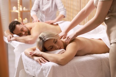 Couple receiving relaxing massage in spa salon, selective focus