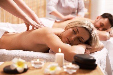 Couple receiving relaxing massage in spa salon, selective focus