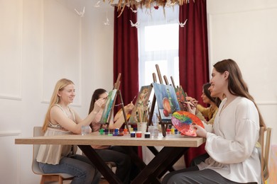 Photo of Group of women learning to draw at table in class