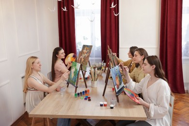 Group of women learning to draw at table in class