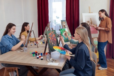 Photo of Group of women learning to draw at table in class