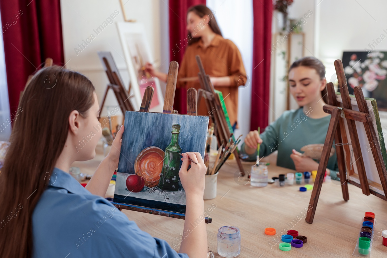 Photo of Group of women learning to draw at wooden table in class