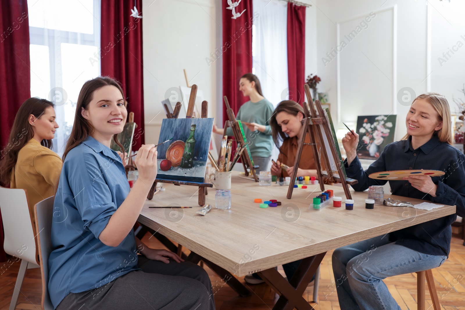 Photo of Group of women learning to draw at wooden table in class