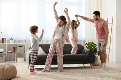 Happy family wearing stylish pajamas having fun at home