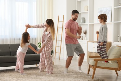 Photo of Happy family wearing stylish pajamas having fun at home