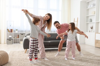 Happy family wearing stylish pajamas having fun at home