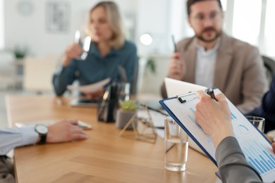 Coworkers working together at table in office, selective focus