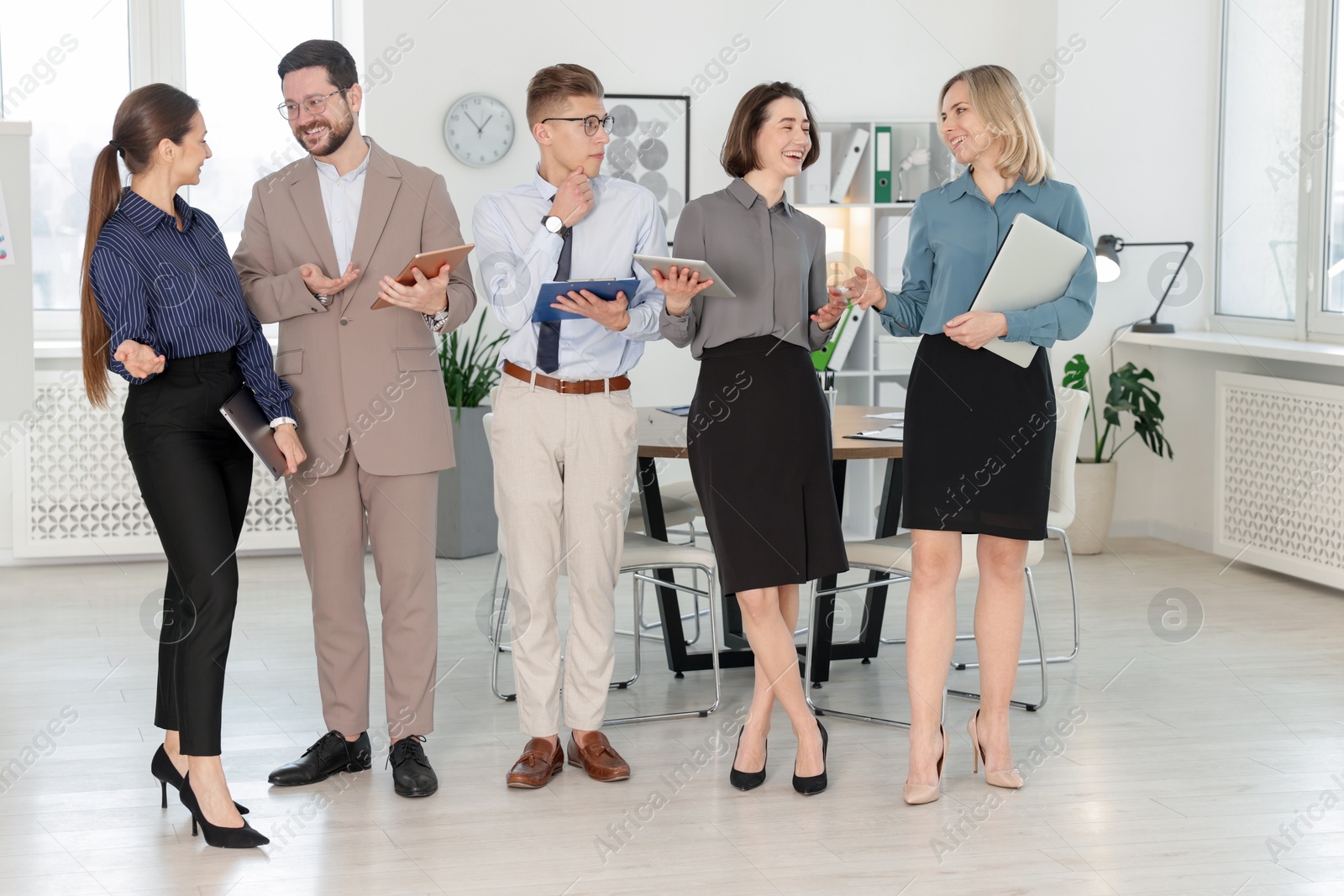 Photo of Group of confident coworkers in formal clothes indoors