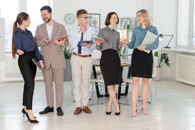 Photo of Group of confident coworkers in formal clothes indoors