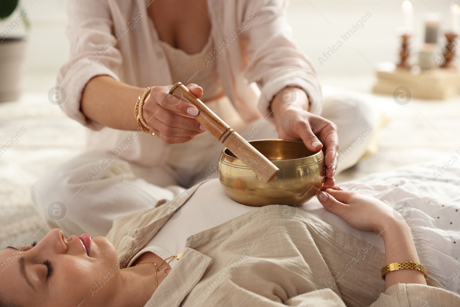 Photo of Woman undergoing singing bowl therapy indoors, closeup